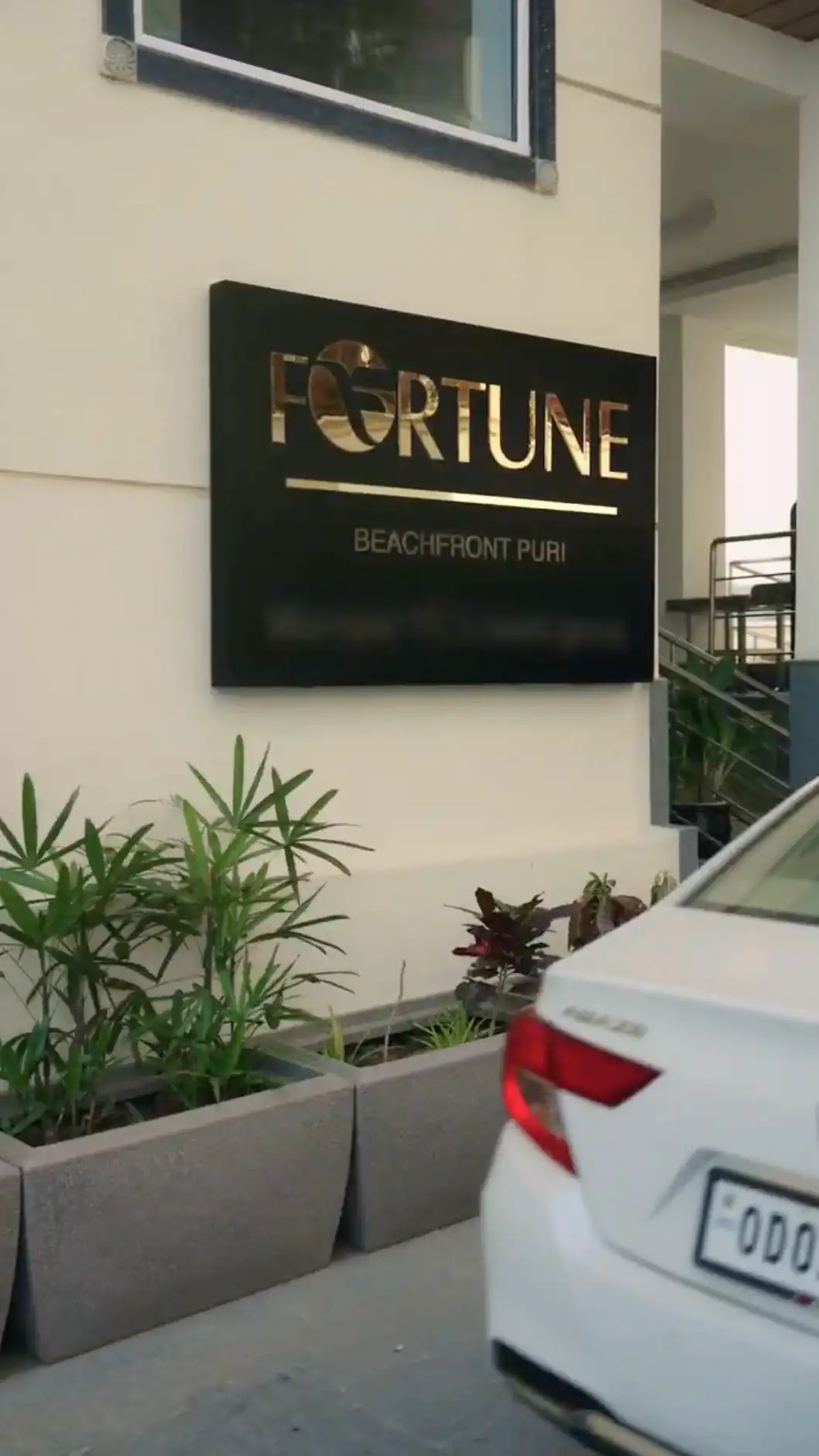 Fortune Beachfront Puri entrance sign beside a white arriving car