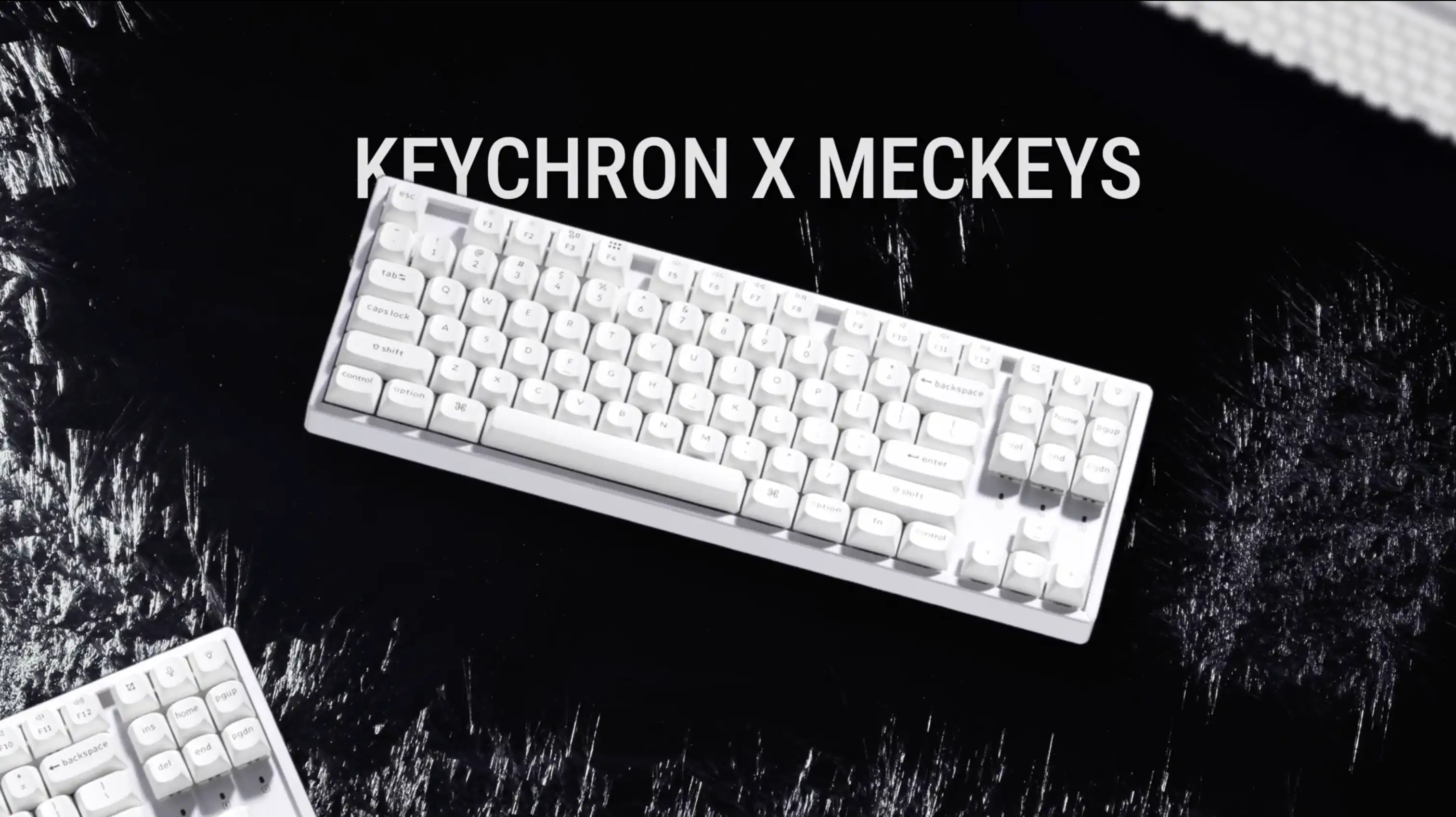 White Keychron keyboard arranged on a black textured surface for Meckeys