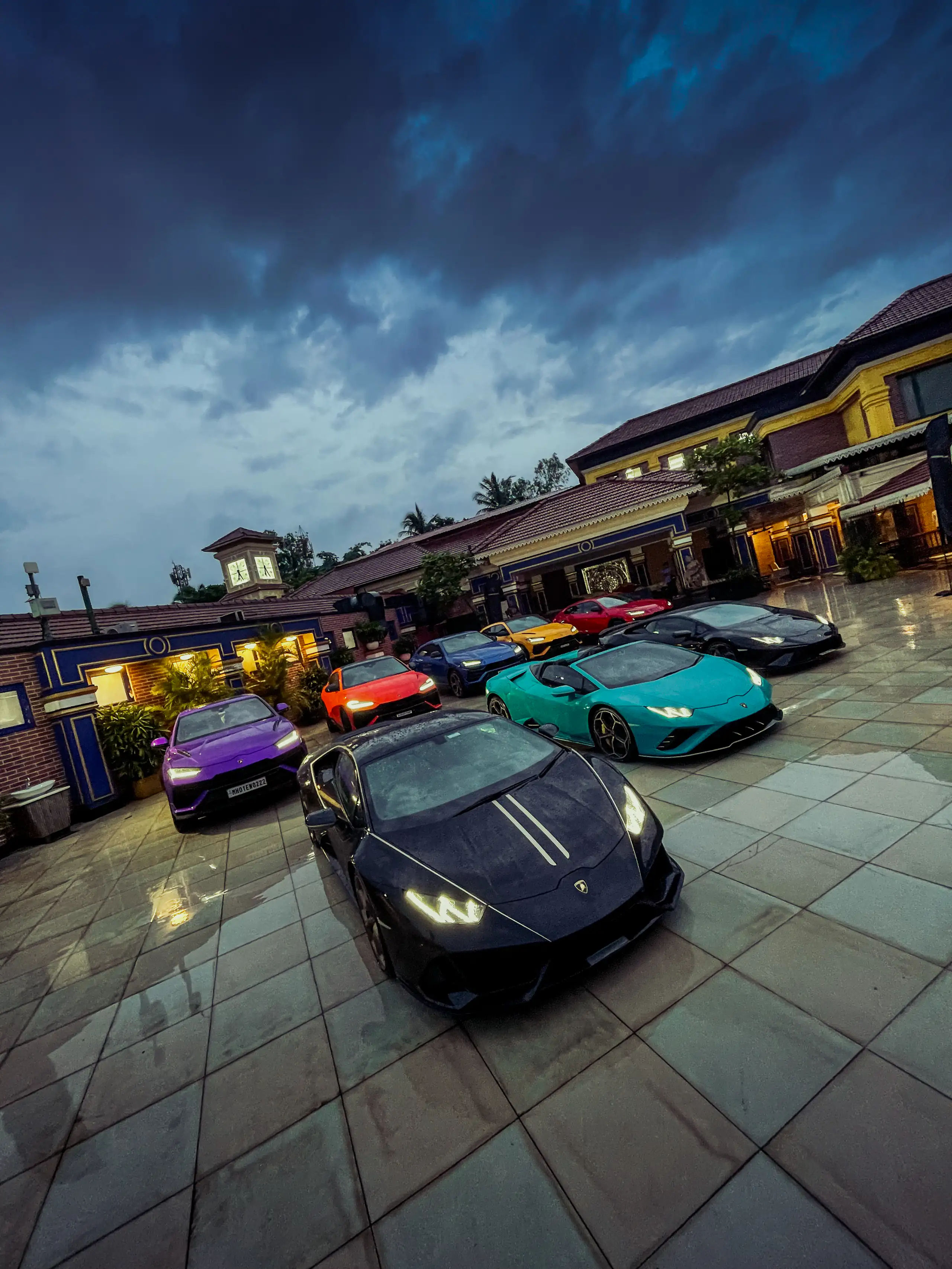 Colourful Lamborghinis gathered on a wet courtyard