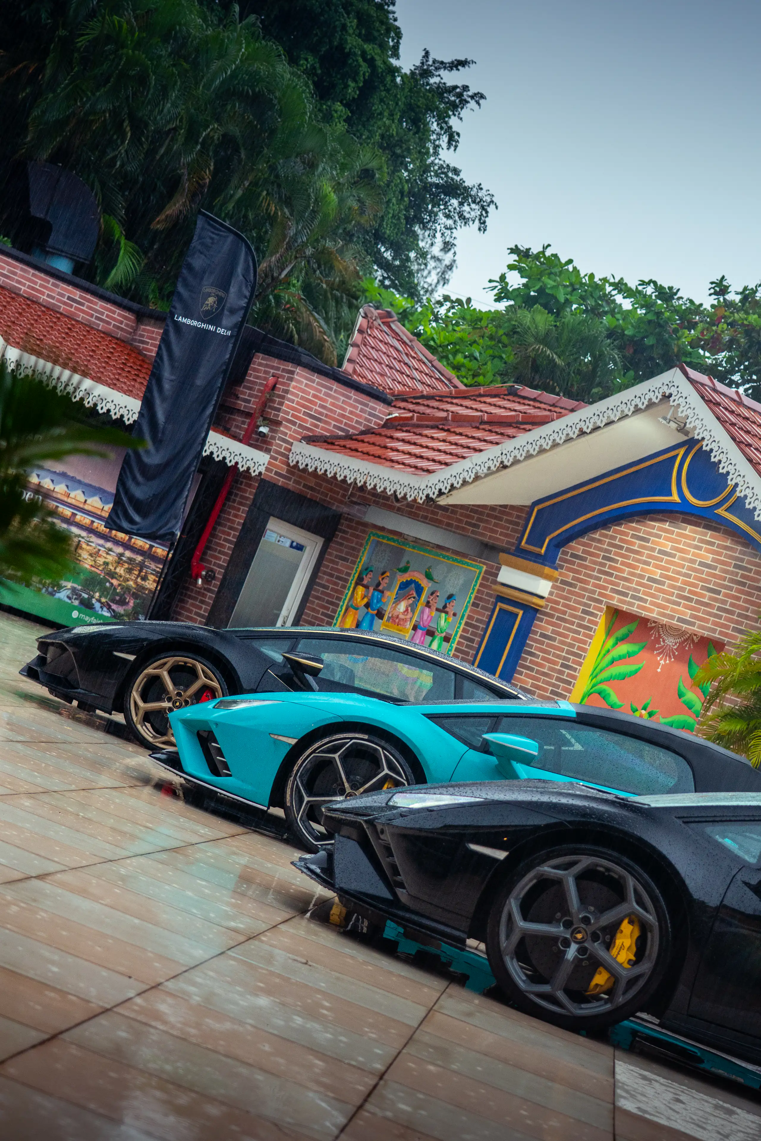 Low diagonal composition of Lamborghinis parked outside a colourful venue