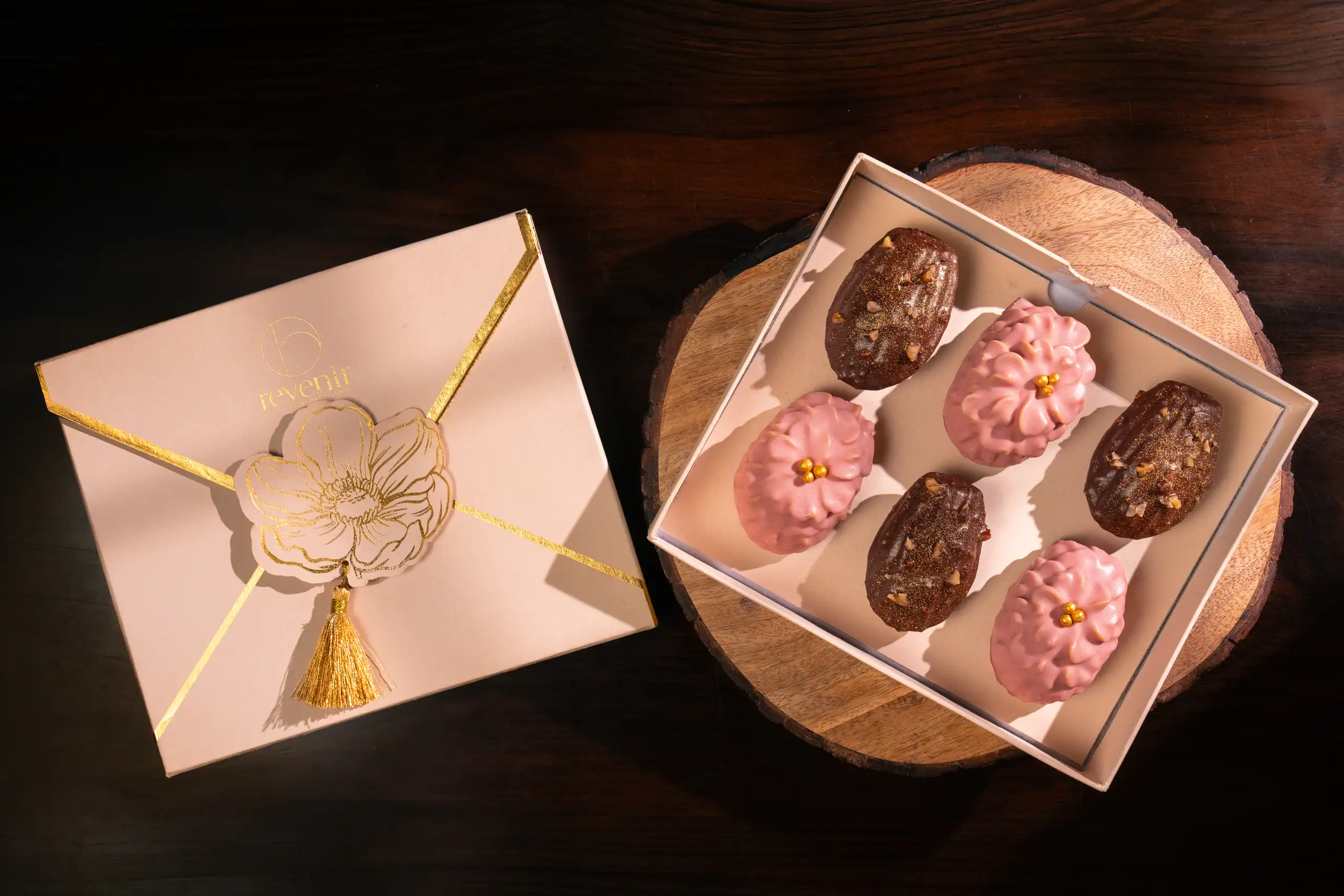 Boxed assortment of pink and chocolate pastries photographed from above