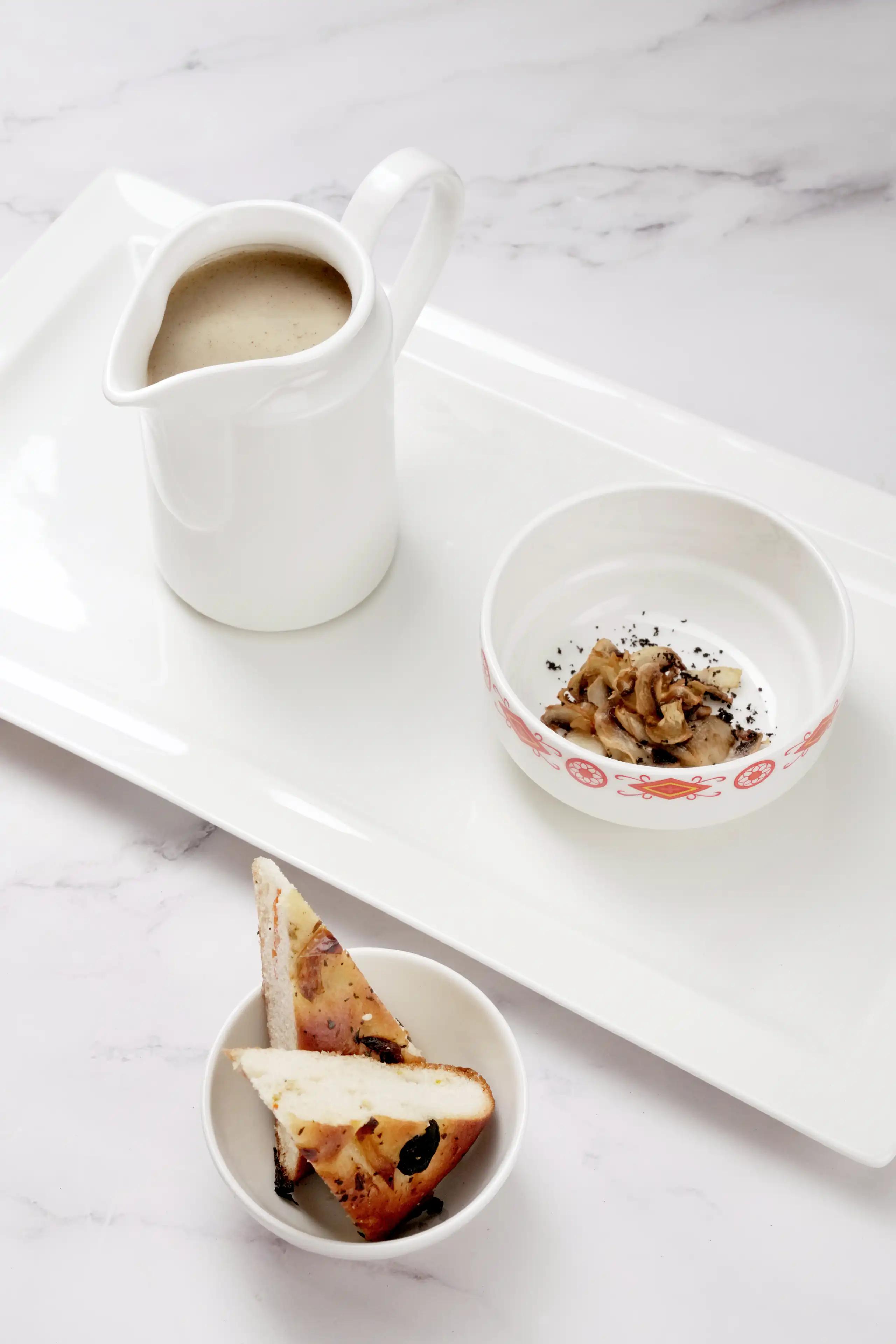 Minimal white table setting with small bowls and a ceramic jug