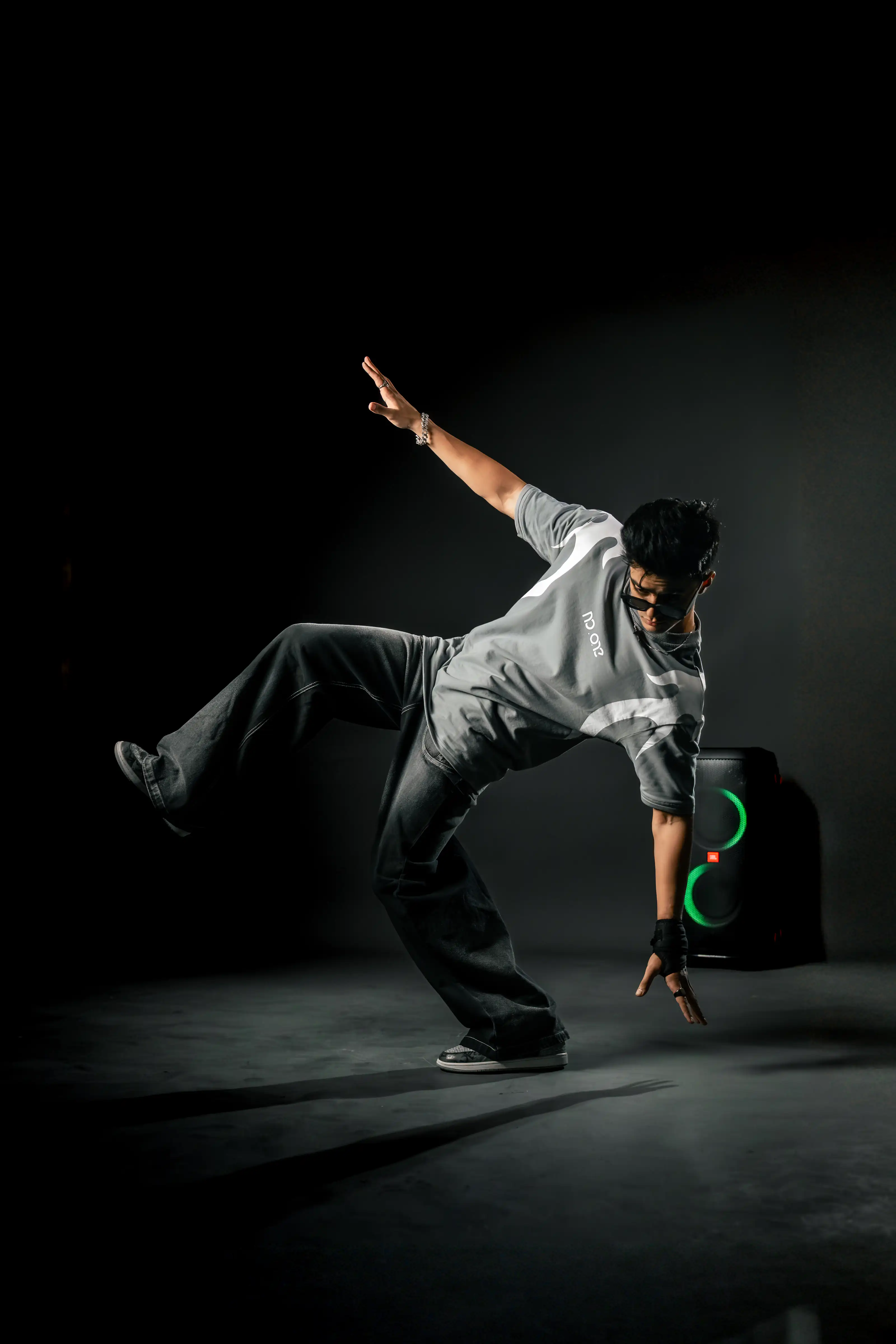 Dancer frozen mid-movement in a dark studio
