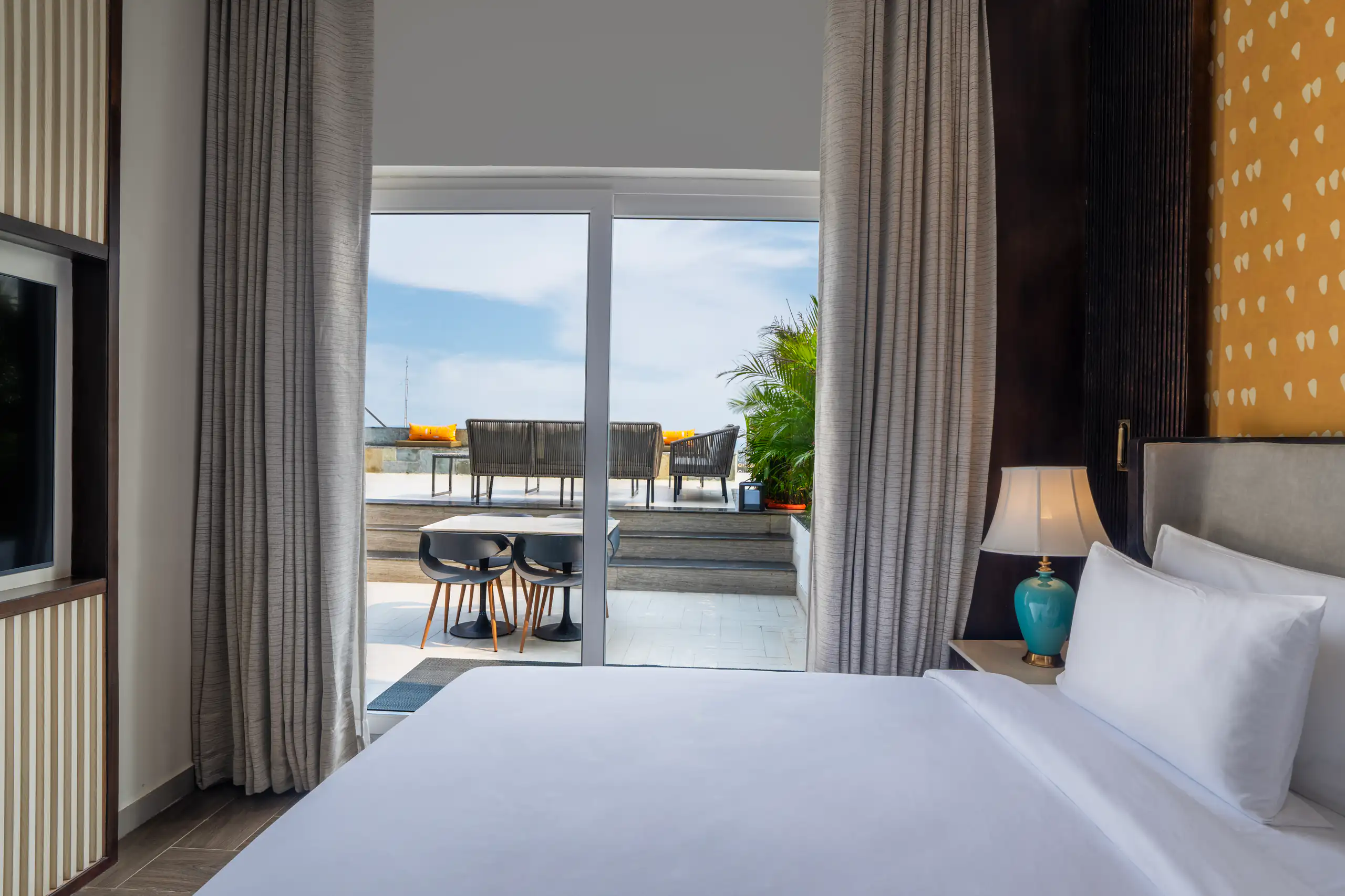 Hotel bedroom opening onto a terrace and distant sea view