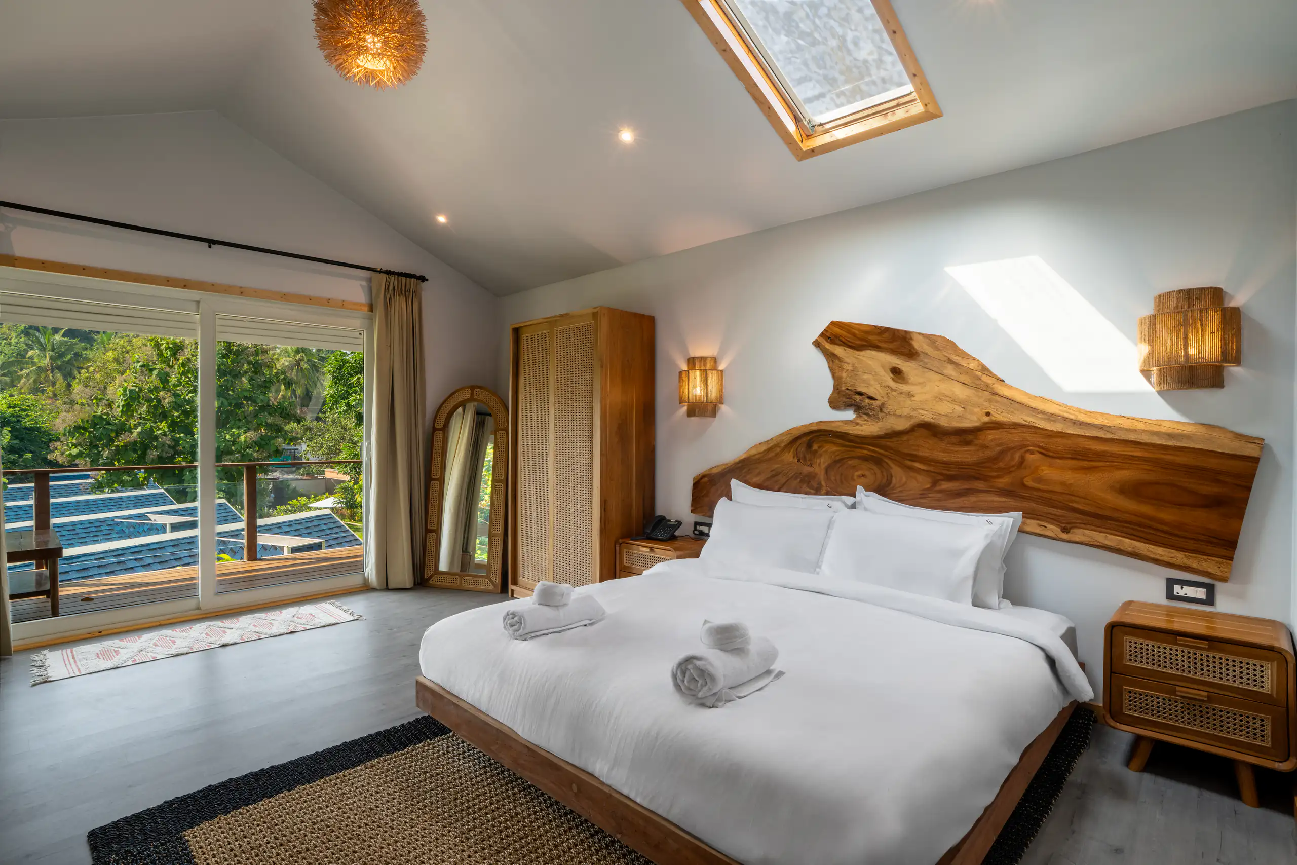 Bright resort bedroom with a sculptural live-edge timber headboard